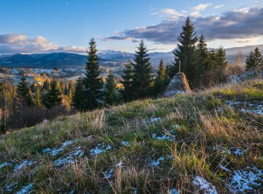 Sonbaharın sonlarında gün batımından önce, tepeleri karla kaplı bir dağ manzarası. Resimli seyahat, mevsimlik, doğa ve kırsal güzellik konsepti. Karpatlar, Ukrayna.