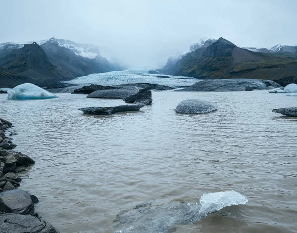 冰川舌从冰川下Rfajkull火山附近的Vatnajokull冰盖或Vatna冰川滑出 有冰块和周围山脉的冰川泻湖 — 图库照片