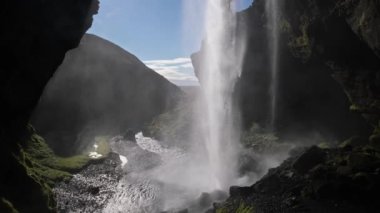Resimli şelale Kvernufoss sonbahar manzarası, güneybatı İzlanda. Güneşin parlama etkisi var. İnsanlar tanınmaz halde..