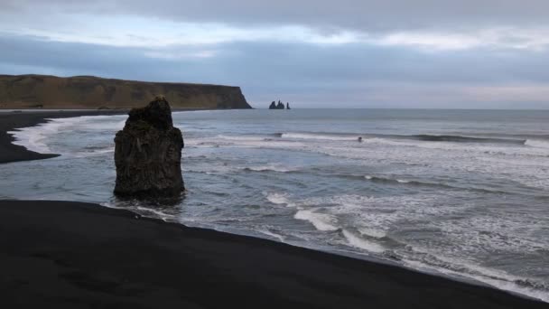 从冰岛南部维克的Dyrholaey Cape到里尼斯法加拉海洋黑色火山灰海滩和岩石形成的秋季傍晚风景如画 里尼斯法尔山作为背景 — 图库视频影像