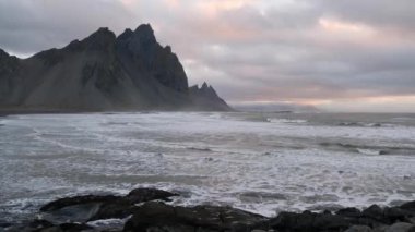 Sunrise Stoksnes Cape Deniz Sahili ve Vestrahorn Dağı ve okyanus sörfü. İnanılmaz doğa manzarası, popüler seyahat merkezi..