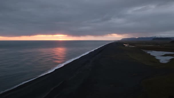 美しい秋の夜の景色は 南アイスランドのヴィク島のダイローレー岬から無限の海の黒い火山砂のビーチへ Vestmannaeyjar島奇妙なシルエットで水平線 — ストック動画
