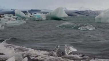 Jokulsarlon Buzul Gölü, İzlanda 'da buzla kaplı bir göl. Breidamerkurjokull buzulu, Vatnajokull buzulu veya Vatna Buzulu 'nun başındaki Atlantik Okyanusu kıyısında. İnsanlar tanınmaz halde..