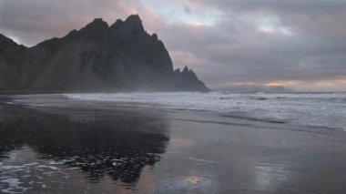 Gündoğumu Stoksnes Cape Deniz Sahili ve Vestrahorn Dağı Islak siyah volkanik kum yüzeyi, İzlanda. İnanılmaz doğa manzarası, popüler seyahat merkezi..