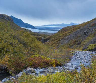 Mulagljufur Kanyonu 'ndan İzlanda' daki Breidarlon buz gölü ile Fjallsarlon Buzulu 'na güzel bir sonbahar manzarası. Halka Yolu 'ndan ve Vatnajokull' un güney ucundaki buz örtüsü ve Oraefajokull volkanından çok uzakta değil..
