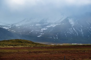 Batı İzlanda Highlands, Snaefellsnes yarımadası, Snaefellsjokull Ulusal Parkı 'ndaki otomobil gezisine bakın. Görkemli volkanik tundra manzarası bulutlarda dağlar.