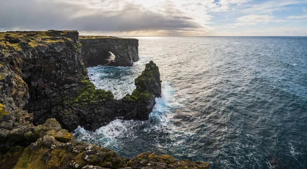 İzlanda 'nın batısındaki dağlık arazi, Snaefellsnes yarımadası, Svortuloft Deniz Feneri' nin yakınındaki View Point 'te araba yolculuğuna bakın. Muhteşem siyah volkanik kayalık okyanus kıyıları, mağara kemerleri ve kuleleri..