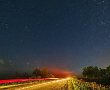 Neowise Kuyruklu Yıldızı C2020 F3 yaz gökyüzünde Ukrayna 'nın Lviv Bölgesi kırsal yolu yakınlarındaki çayır üzerinde uçarken.