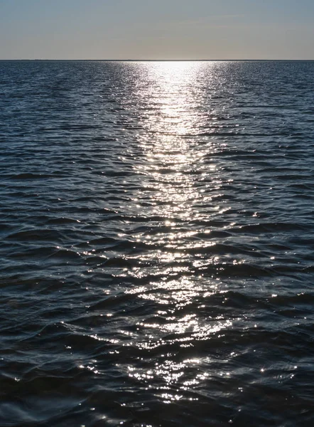 夜の日差しの輝きは海面に反射します 波の上に海面上の輝く太陽 輝く水の背景 — ストック写真