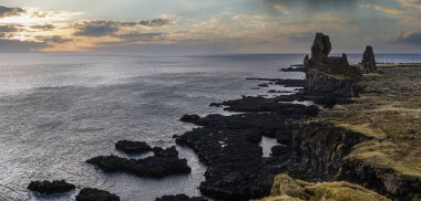 Batı İzlanda, Snaefellsnes yarımadası, Snaefellsjokull Ulusal Parkı, Londrangar Manzara Noktası 'ndaki araba gezisine bakın. Muhteşem siyah volkanik kayalık okyanus kıyıları, kayalıklardaki tarihi volkanik kuleler.