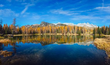 Autumn alpine mountain lake near San Pellegrino Pass, Trentino, Dolomites Alps, Italy. Picturesque traveling, seasonal and nature beauty concept scene.