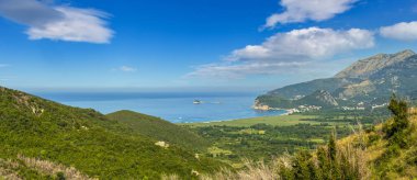 Yaz sabahı Adriyatik kıyı şeridi (Budva ile Karadağ 'ın Bar kenti arasındaki Buljarica Sahili) yukarıdan görülüyor. Panorama.