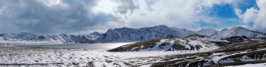 İzlanda dağlarında mevsim değişimi. Sonbaharda kar altında renkli Landmannalaugar dağları. Dağın eteğindeki Frostastadavatn Gölü.
