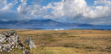 İzlanda 'da otomobil gezisi sırasında görüntüle. Manzaralı İzlanda manzarası: dağlar, okyanus kıyıları, fiyortlar, tarlalar, bulutlar, buzullar, şelaleler.