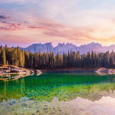 Sunny colorful autumn alpine Dolomites mountain scene, Sudtirol, Italy. Karersee or Lago di Carezza view. Picturesque traveling, seasonal, nature and countryside beauty concept scene.