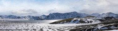 İzlanda dağlarında mevsim değişimi. Sonbaharda kar altında renkli Landmannalaugar dağları. Dağın eteğindeki Frostastadavatn Gölü.