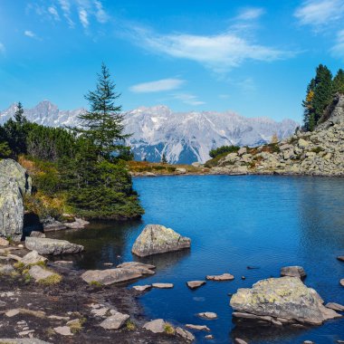 Güneşli sonbahar dağ manzarası. Şeffaf su ve yansımalarıyla huzurlu dağ ormanı gölü. Spiegelsee veya Mittersee veya Mirror Lake, Reiteralm, Steiermark, Avusturya.