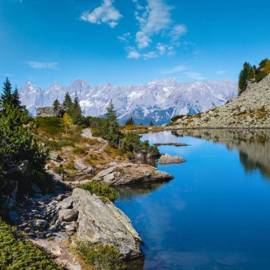 Güneşli sonbahar dağ manzarası. Şeffaf su ve yansımalarıyla huzurlu dağ ormanı gölü. Spiegelsee veya Mittersee veya Mirror Lake, Reiteralm, Steiermark, Avusturya.
