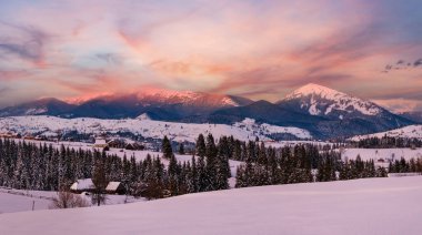 Alp köyü dün akşam günbatımında Panorama 'nın dışında. Kış karlı tepeler ve köknar ağaçları, uzaklardaki görkemli ve pitoresk dağ sıraları. Voronenko, Ukrayna, Karpatlar.