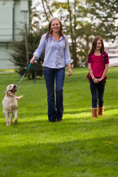 Mom And daughter walking the dog — Stock Photo, Image