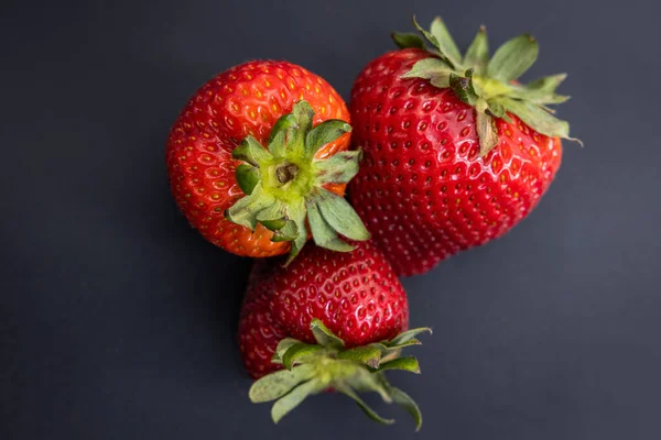 Close Van Drie Rijpe Rode Aardbeien Een Donkere Reflecterende Achtergrond — Stockfoto