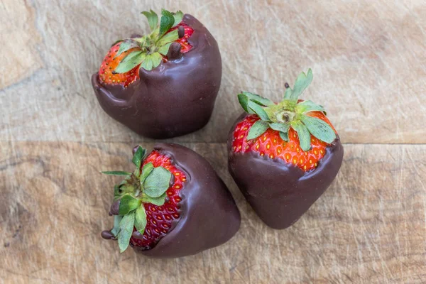 Schokoladenüberzogene Erdbeeren Isoliert Auf Einem Hölzernen Hintergrund — Stockfoto