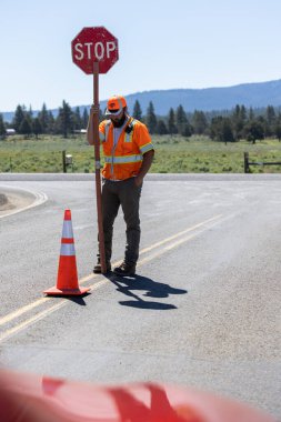 Beatty, Oregon / ABD - 22 Haziran 2022: 140 numaralı karayolu inşaatı için geçici bir dur işareti tutan bayrak