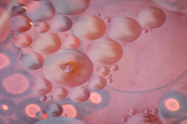 Suda yüzen yağ damlalarının kırmızı arkaplanlarını soyut olarak kapat