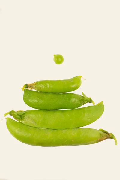 Beyaz arkaplanda taze yeşil bezelyeler.