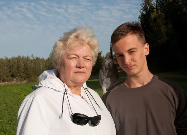 Бабушка и внук с попугаем . — стоковое фото
