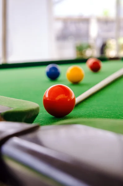 Snooker balls with stick on green surface, shallow depth of field — Stock Photo, Image