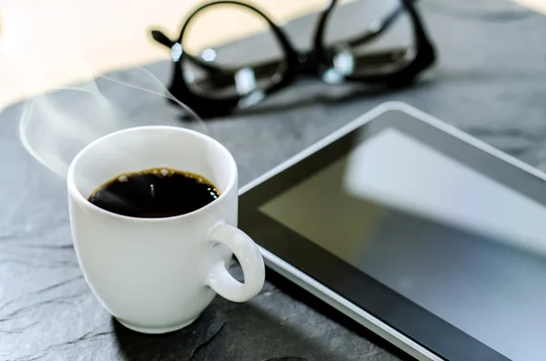 Taza de café, vasos y tabletas en la mesa de piedra —  Fotos de Stock