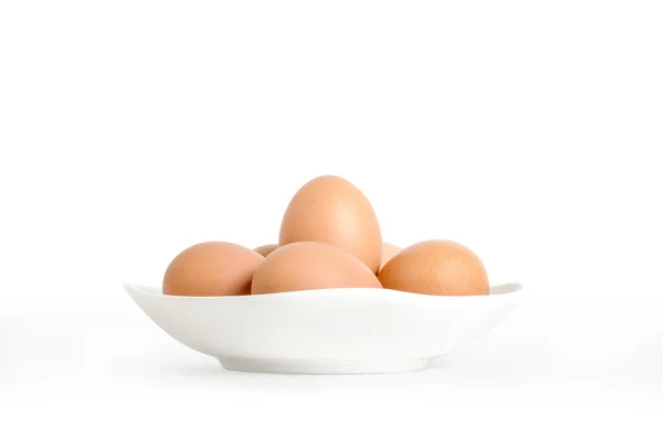 Яйца в белой тарелке на белом фоне — стоковое фото