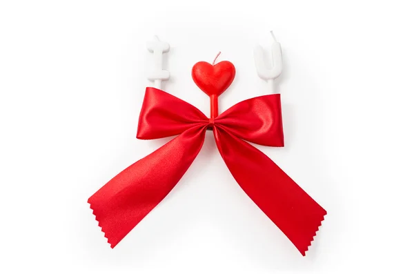 Red gift bow and candles making 'I love you' isolated on white — Stock Photo, Image