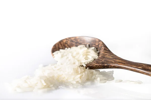 Ris spannmål och trä sked på vit bakgrund — Stockfoto