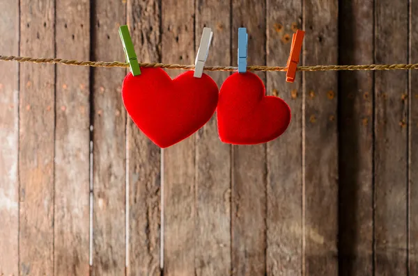 Mignon grand coeur rouge accroché à la corde à linge. Sur fond de vieux bois . — Photo