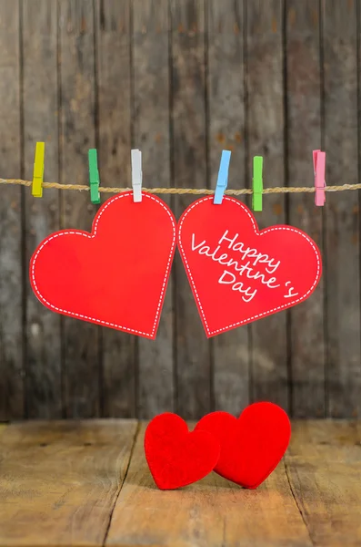 Cute big red heart hanging on the clothesline. On old wood background. — Stock Photo, Image