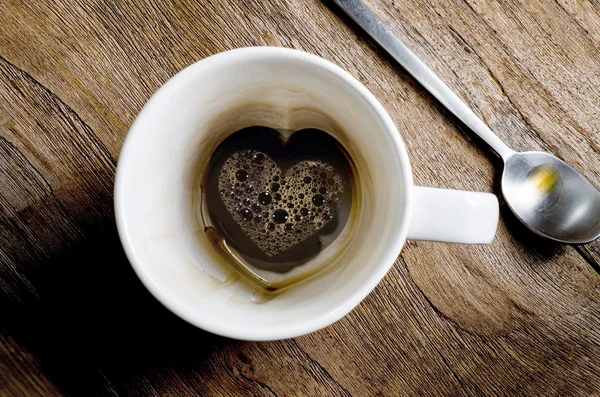 Café de xícara com símbolo de coração em um fundo de mesa de madeira — Fotografia de Stock