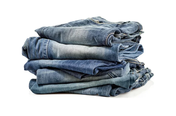 Gefaltete alte blaue Jeans isoliert auf einem weißen. Schneidpfad inklusive. — Stockfoto