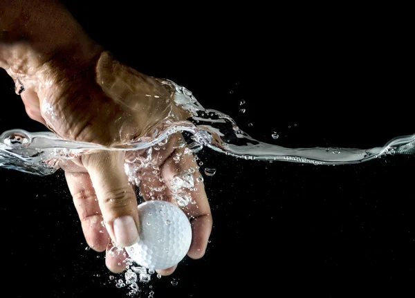 Hand nimmt Golfball auf, der im Wasser planscht. — Stockfoto