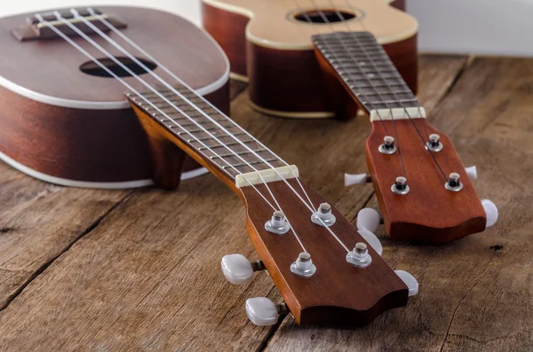 Ukuleles tegen een houten achtergrond. — Stockfoto