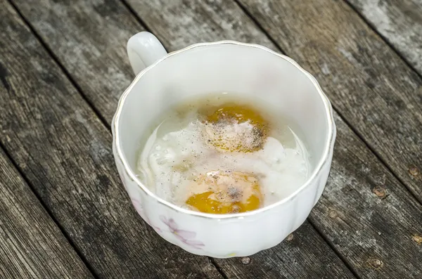 Měkké vařené vejce v poháru na dřevěné pozadí — Stock fotografie