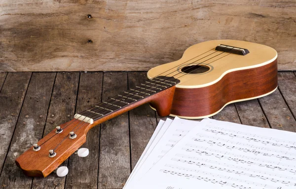 Ukulele en papier chordschart document op houten achtergrond — Stockfoto