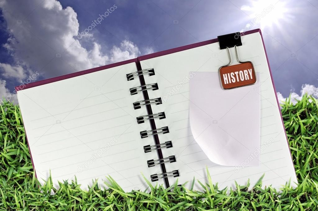 Blank notebook on the Green Meadow and Blue Sky Background