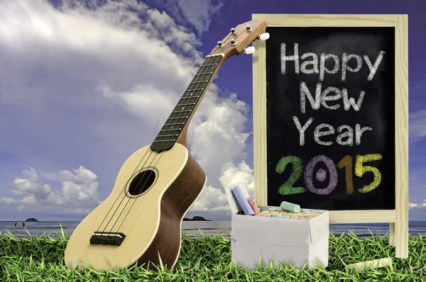 Ukelele met blauwe hemel en schoolbord 2015 tekst op het gras — Stockfoto