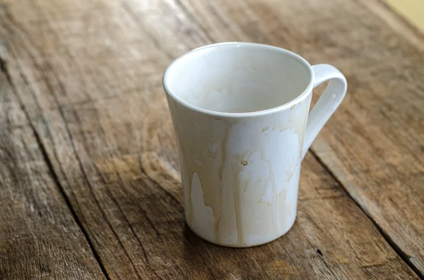 Caneca de café vazia, com manchas no fundo de madeira — Fotografia de Stock