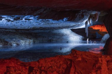 Underground lake reflects ceiling cave formations. clipart