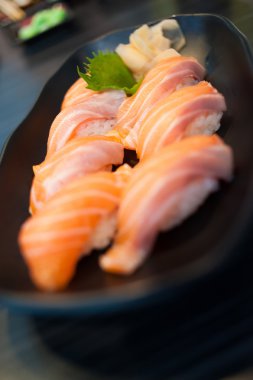 Somon suşi seti siyah çanak üzerinde kapat