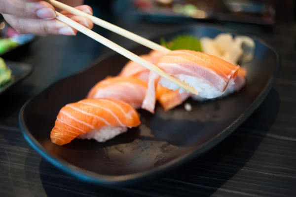 Закрыть лососевые суши на черном блюде — стоковое фото