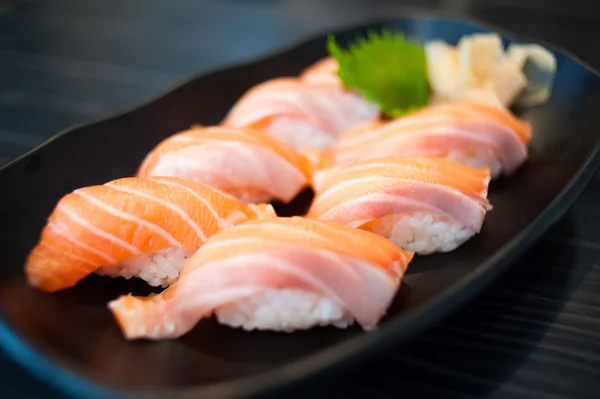 Закрыть лососевые суши на черном блюде — стоковое фото